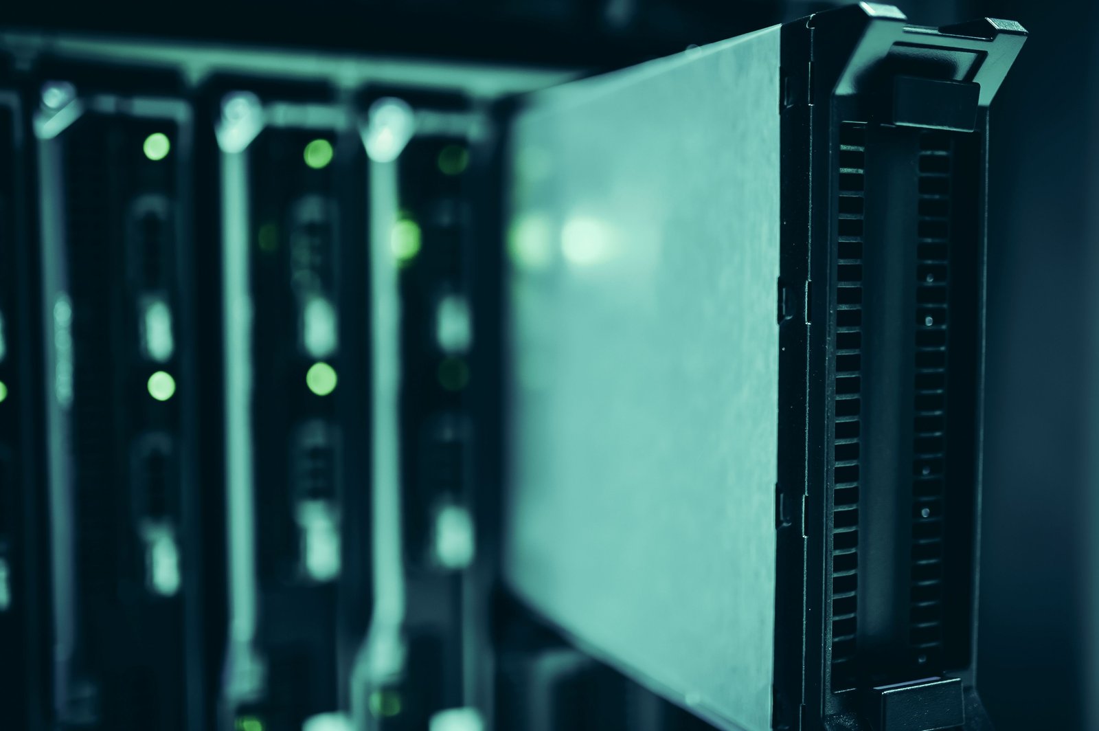 Business servers in a data center lit by green indicator lights